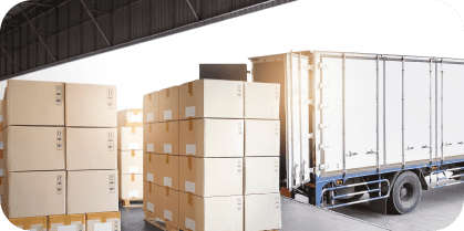 un camión descarga estibas cargadas de cajas en centro logístico